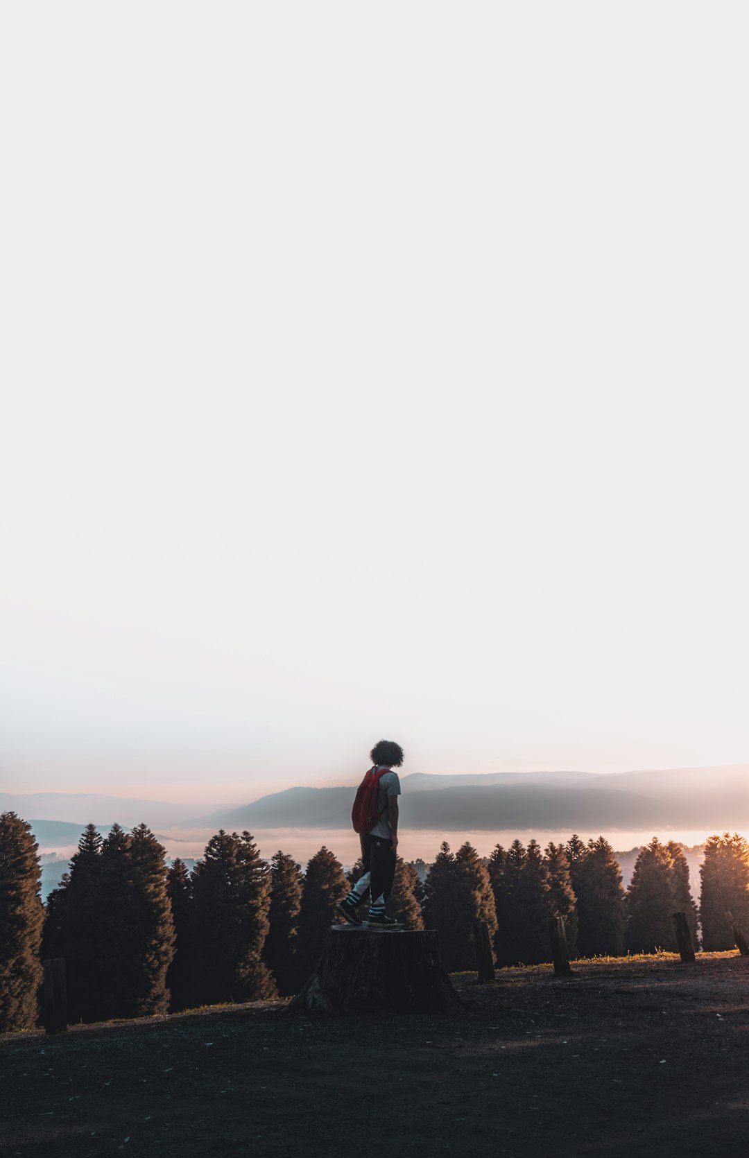 man in black jacket standing on rock formation during daytime