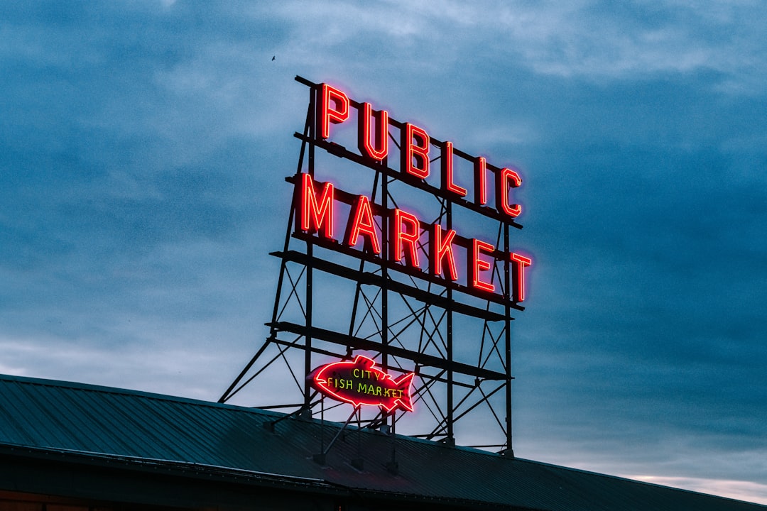 red and black UNKs neon light signage, The Seattle Public Market sign at blue hour lit up.