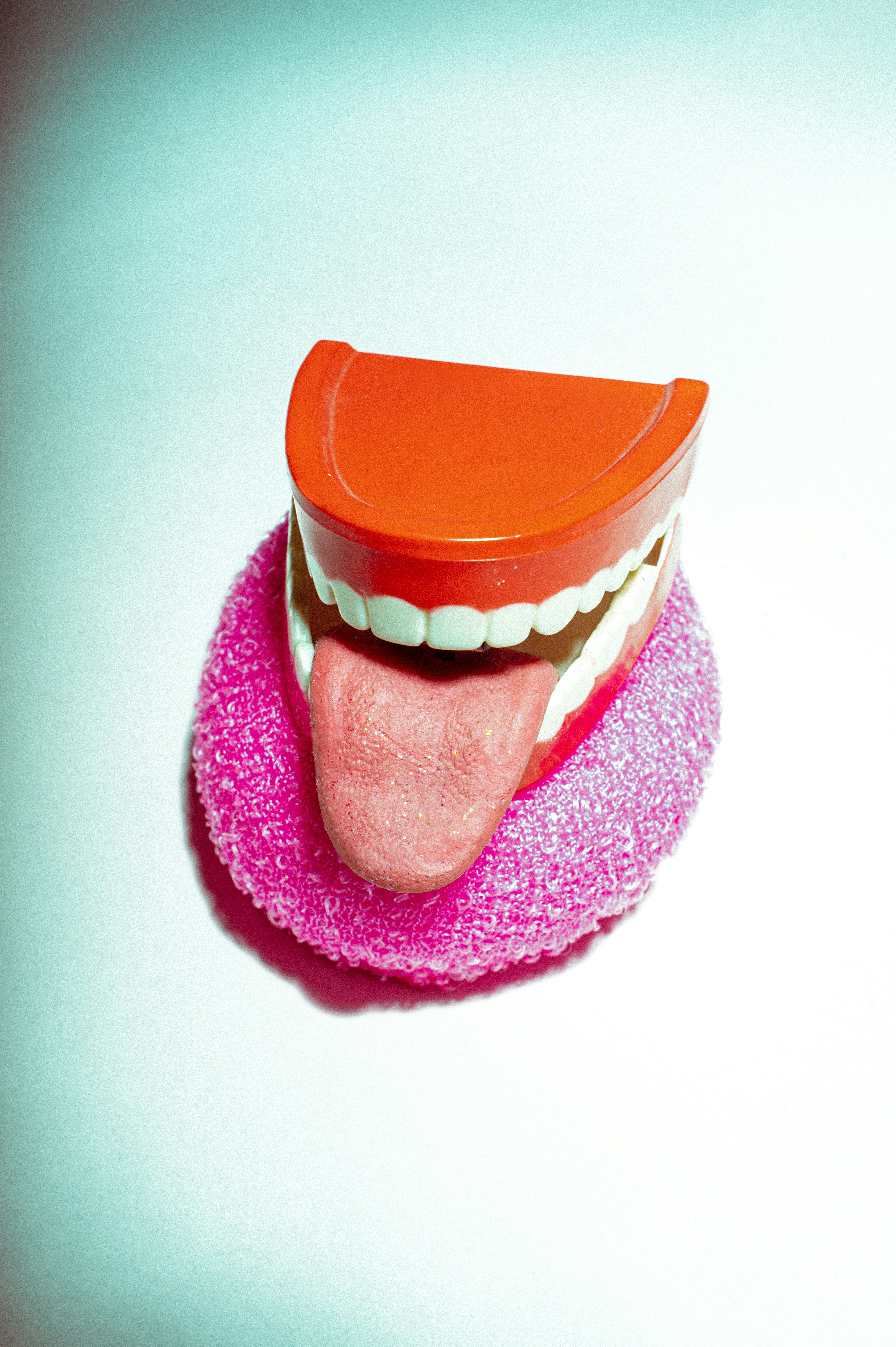 Wind up Toy Smile with the tongue out on top of pink sponge