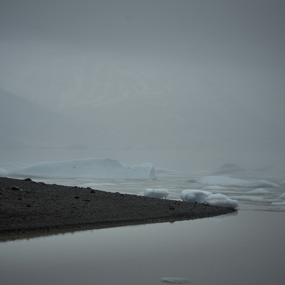 snow covered mountain near body of water during daytime