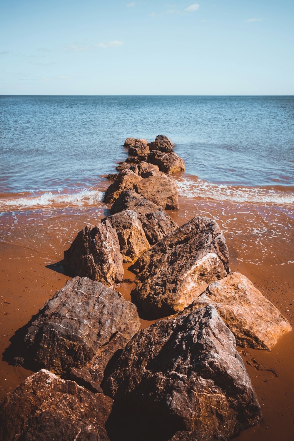 brown and gray rock formation near body of water during daytime