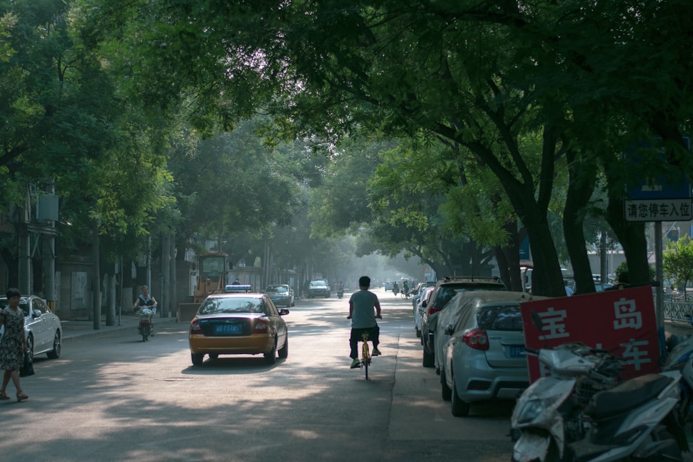 people walking on sidewalk with cars parked on side of the road during daytime