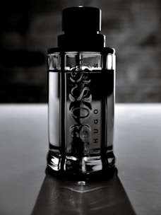close-up of a sleek, gold-capped intimate lubricant bottle on dark charcoal background