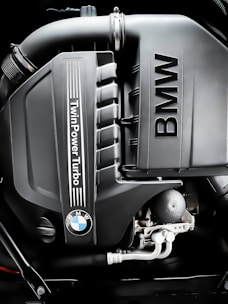 A BMW technician carefully inspecting a diesel engine with precision instruments.