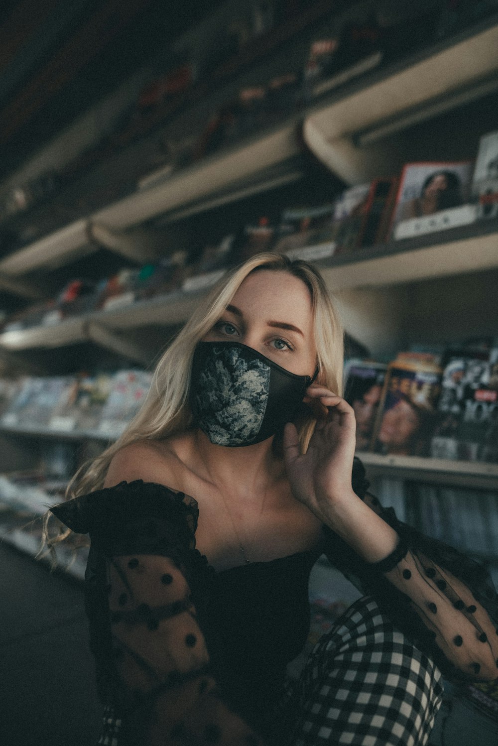 woman in black sunglasses holding black bear plush toy