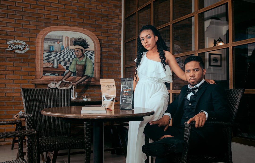 man and woman standing beside brown wooden table