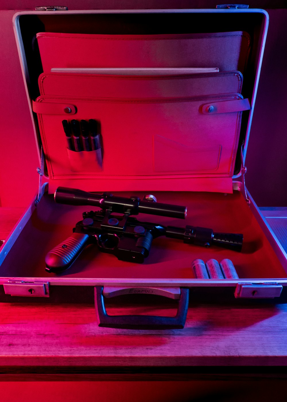 black and red semi automatic pistol in red plastic container