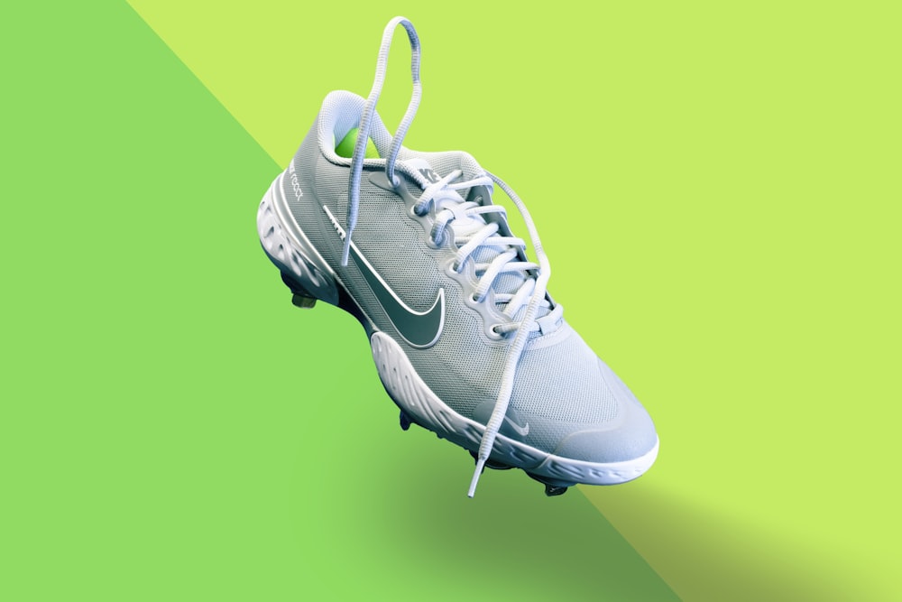 white nike athletic shoe on green textile