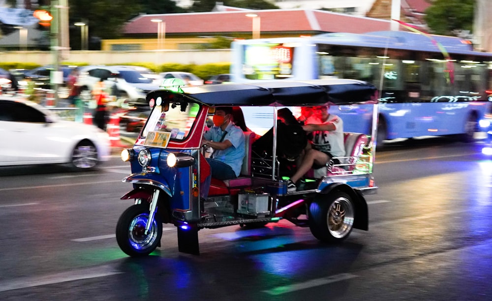 2 people riding on blue and white auto rickshaw