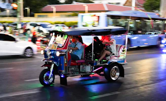 2 people riding on blue and white auto rickshaw