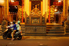 Happy tourists gearing up on scooters near Jagannath Temple, smiling and ready to ride.