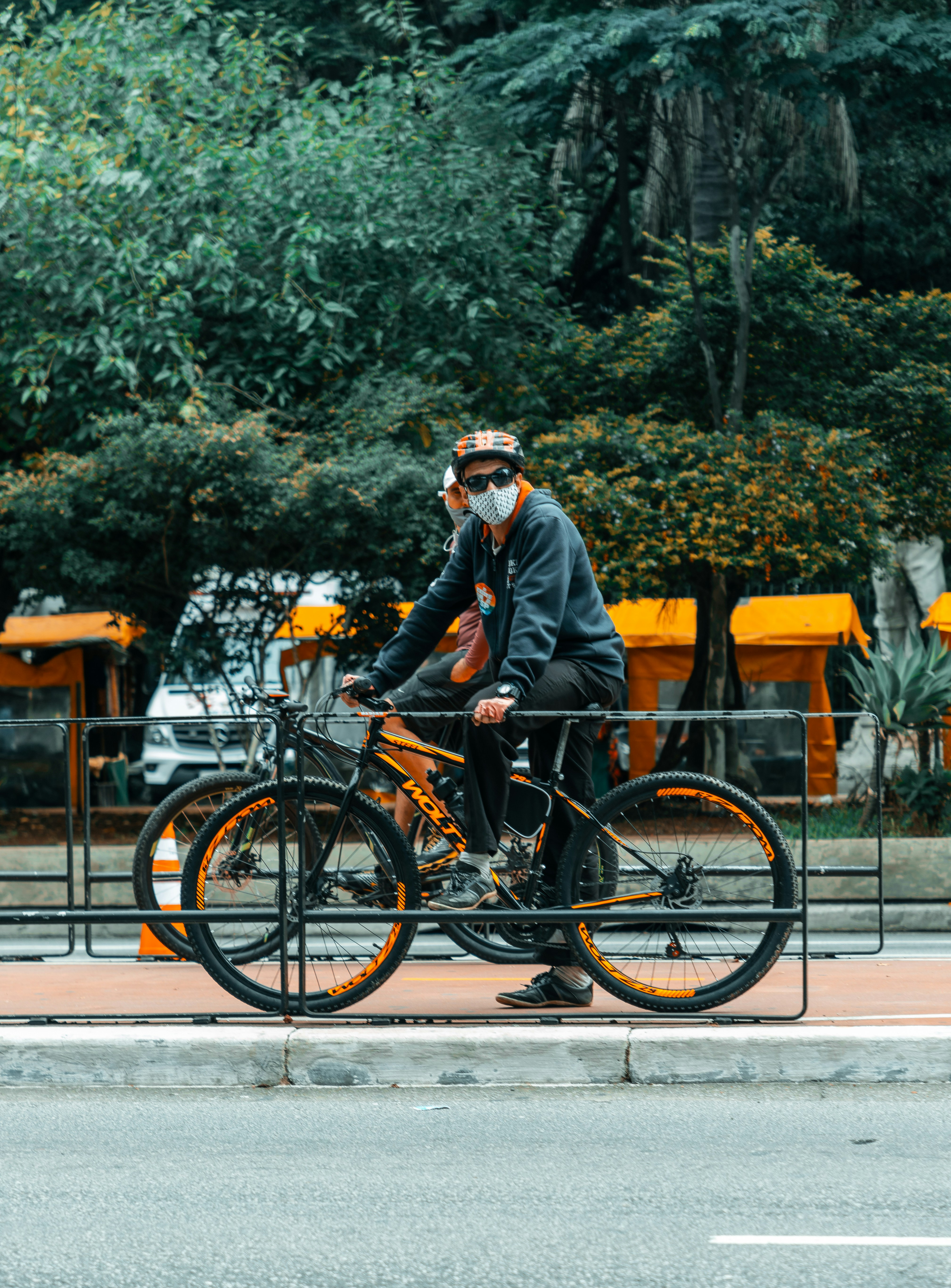 man in black jacket riding bicycle during daytime