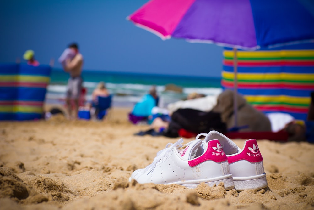 white and red nike sneakers on beach