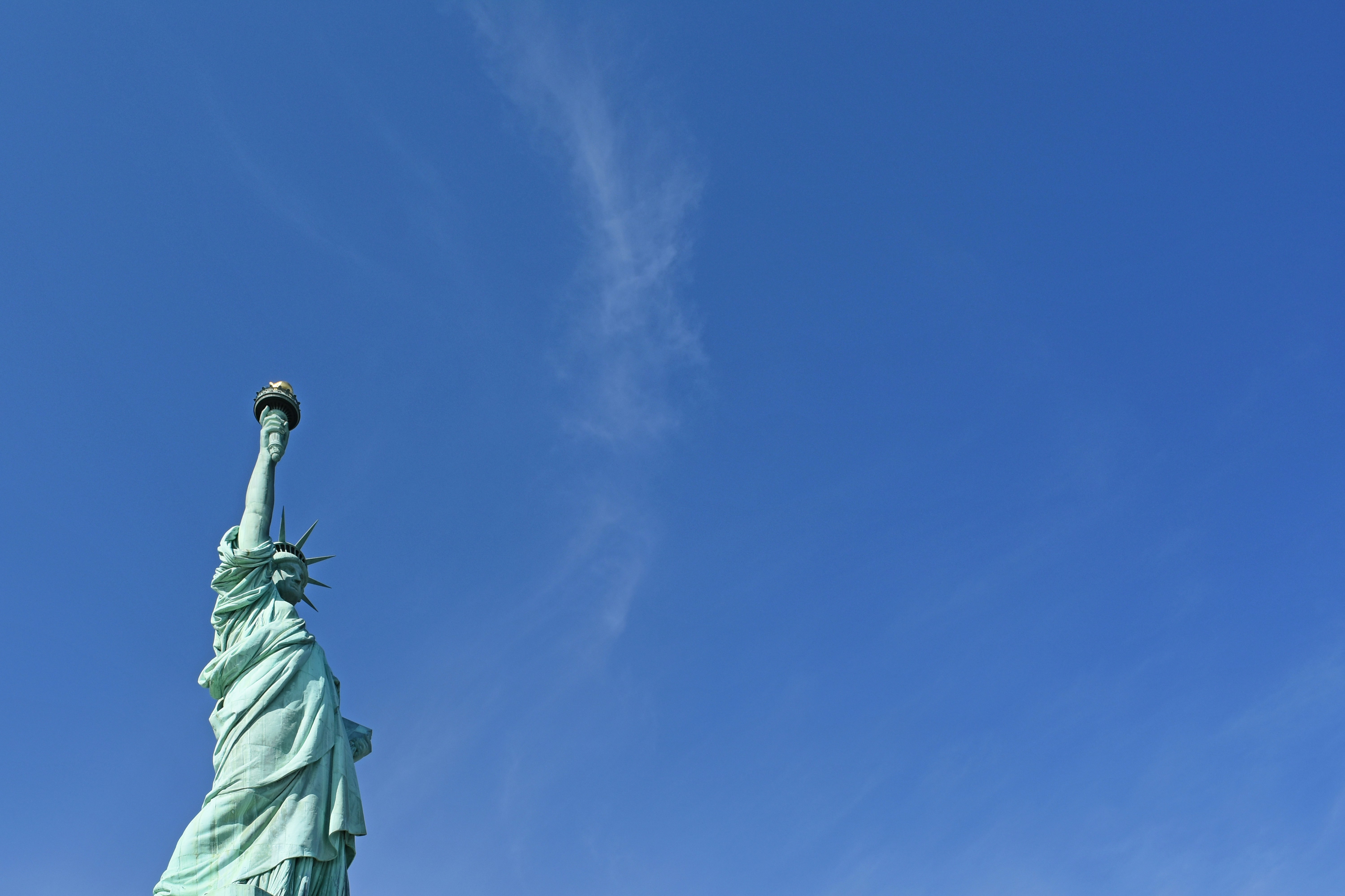 Statue of Liberty against a blue sky. Liberty Island, New York, USA [Photo: April 2019]