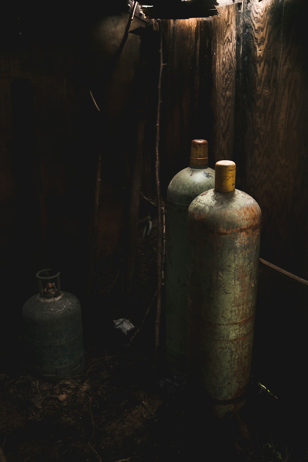 3 black propane tank on brown wooden floor