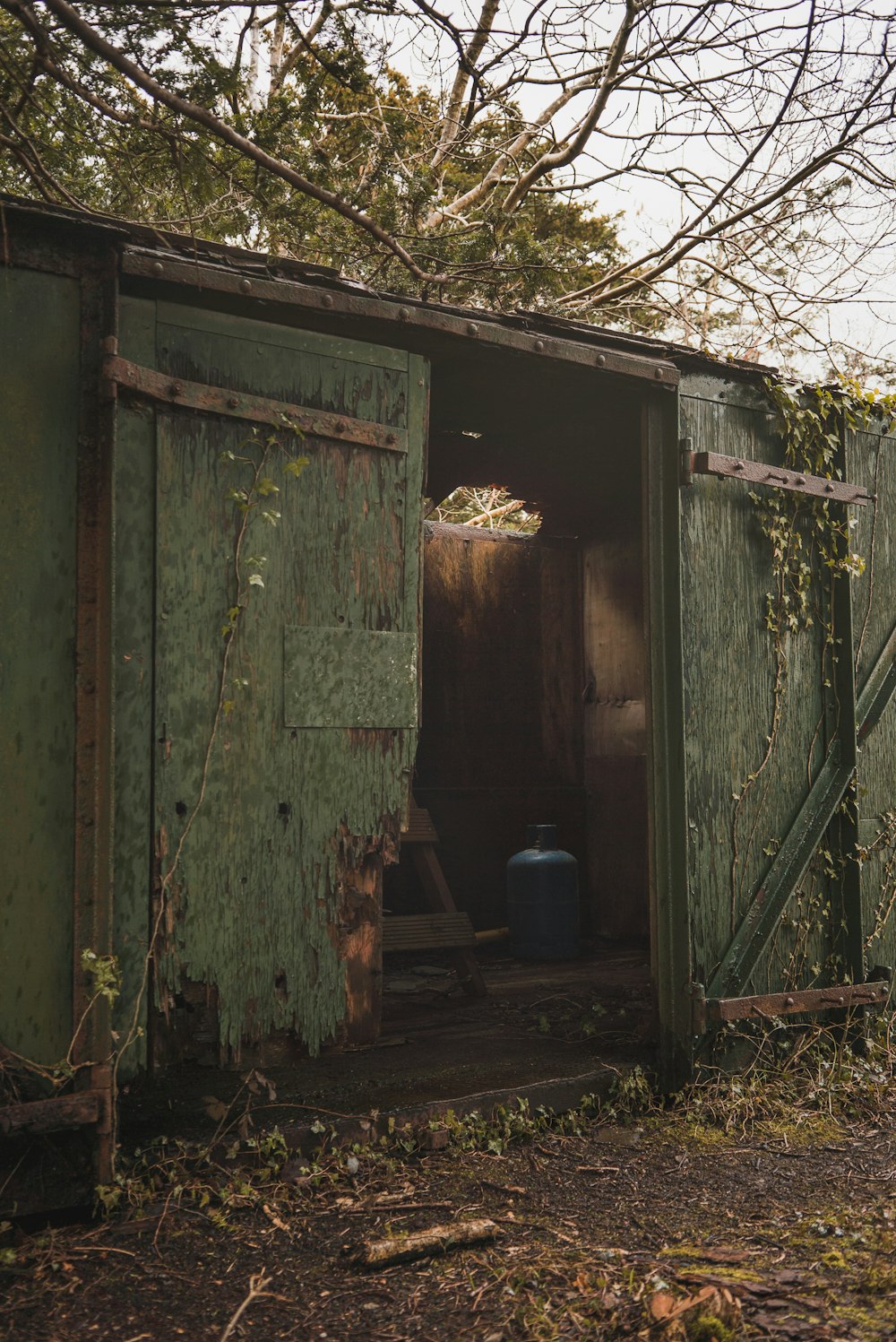 green wooden door near blue plastic container