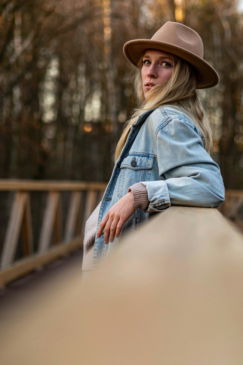 woman in blue denim jacket and brown fedora hat