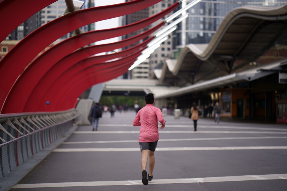 Homme en T-shirt rouge courant sur le pont