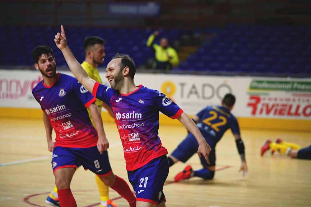 2 mulheres na camisa da camisa vermelha e azul jogando futebol