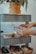 Man happily arranging containers on a neat pantry shelf.