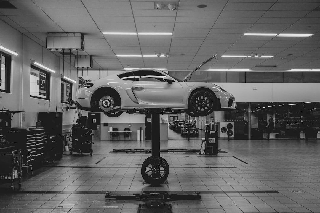 grayscale photo of car in a parking lot