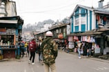 A vibrant street scene at Benachity Bazar with colorful shops and busy shoppers.