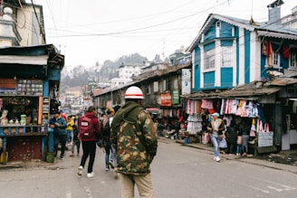 A bustling street scene in Prishtina with people walking and local shops lining the sidewalks.