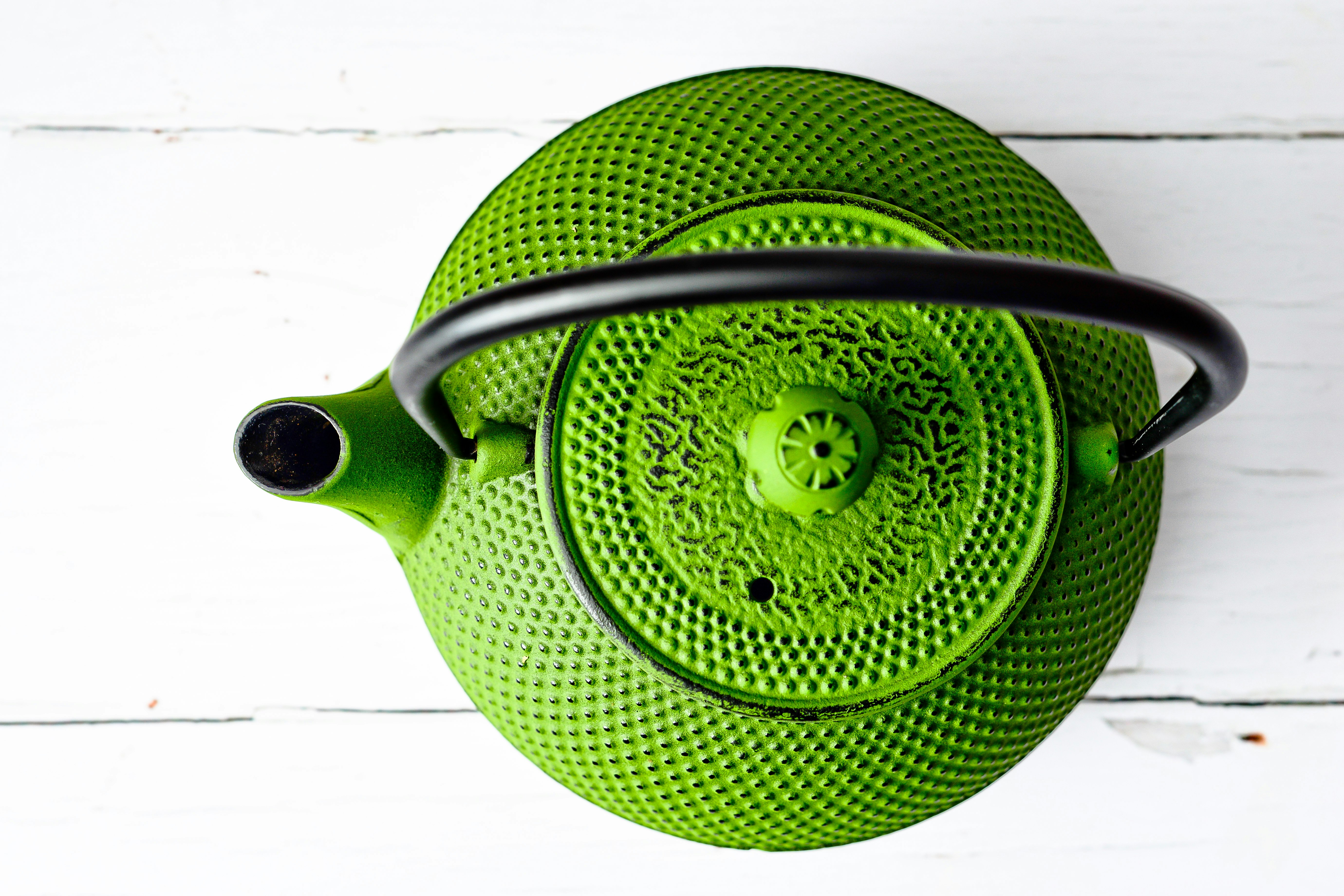 green and black ceramic teapot