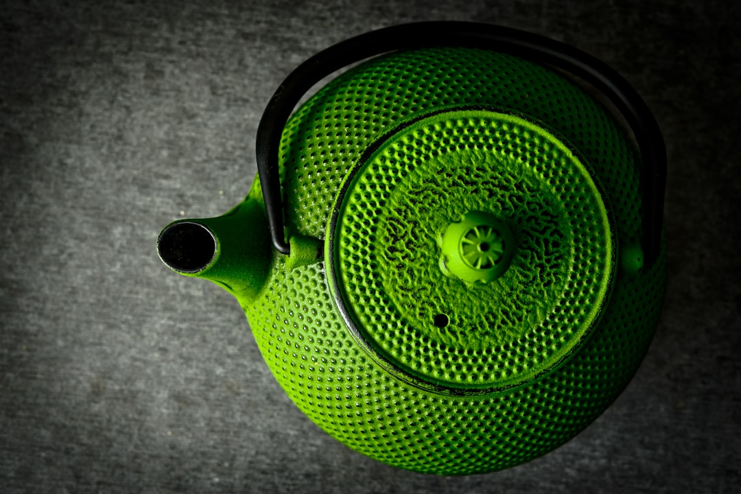 green and black ceramic teapot