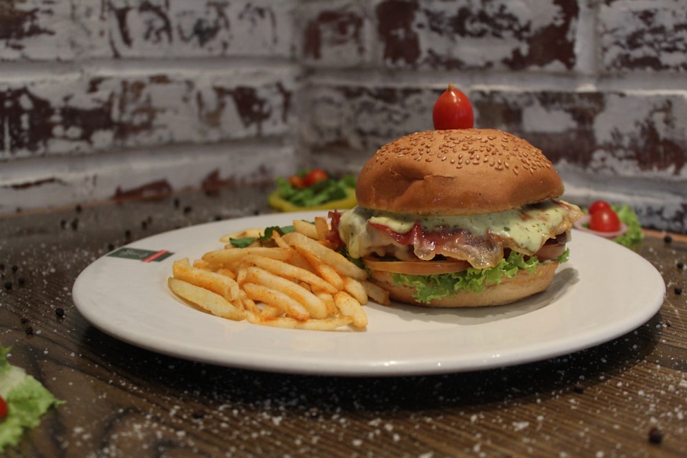 burger with lettuce and tomato on white ceramic plate