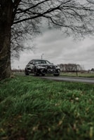 A sleek European estate car parked by a scenic countryside road.