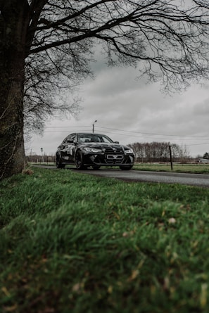 A sleek European estate car parked by a scenic countryside road.