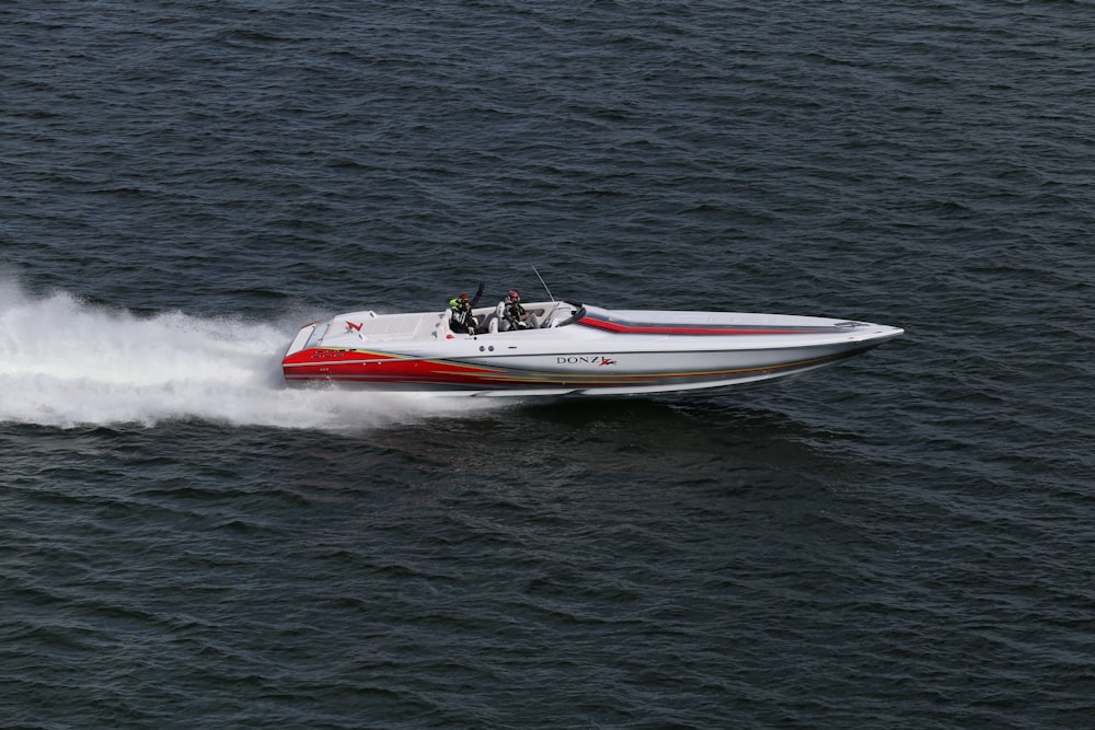 barco branco e vermelho na água durante o dia