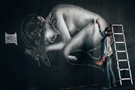 An artist painting a mural on a city wall.