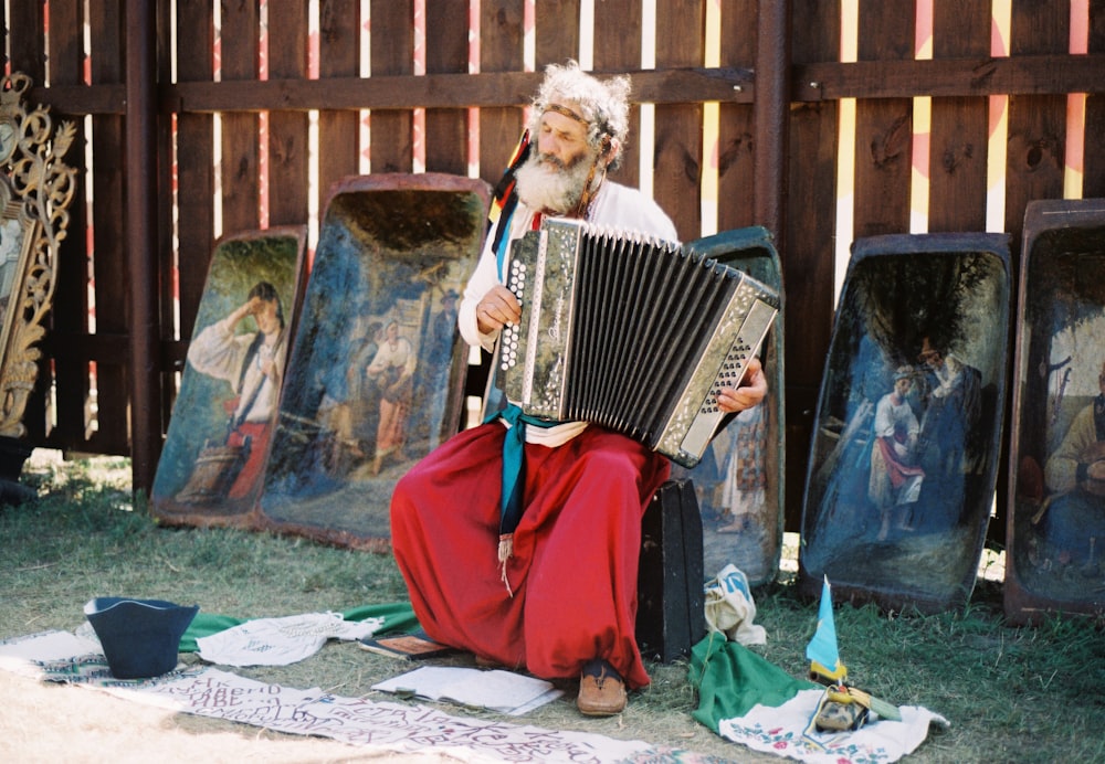 woman in red dress playing white and black accordion