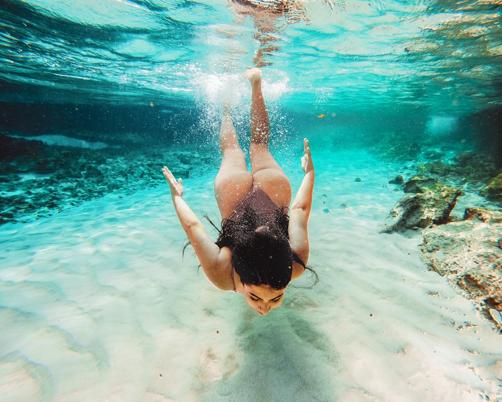woman in black bikini swimming in the water