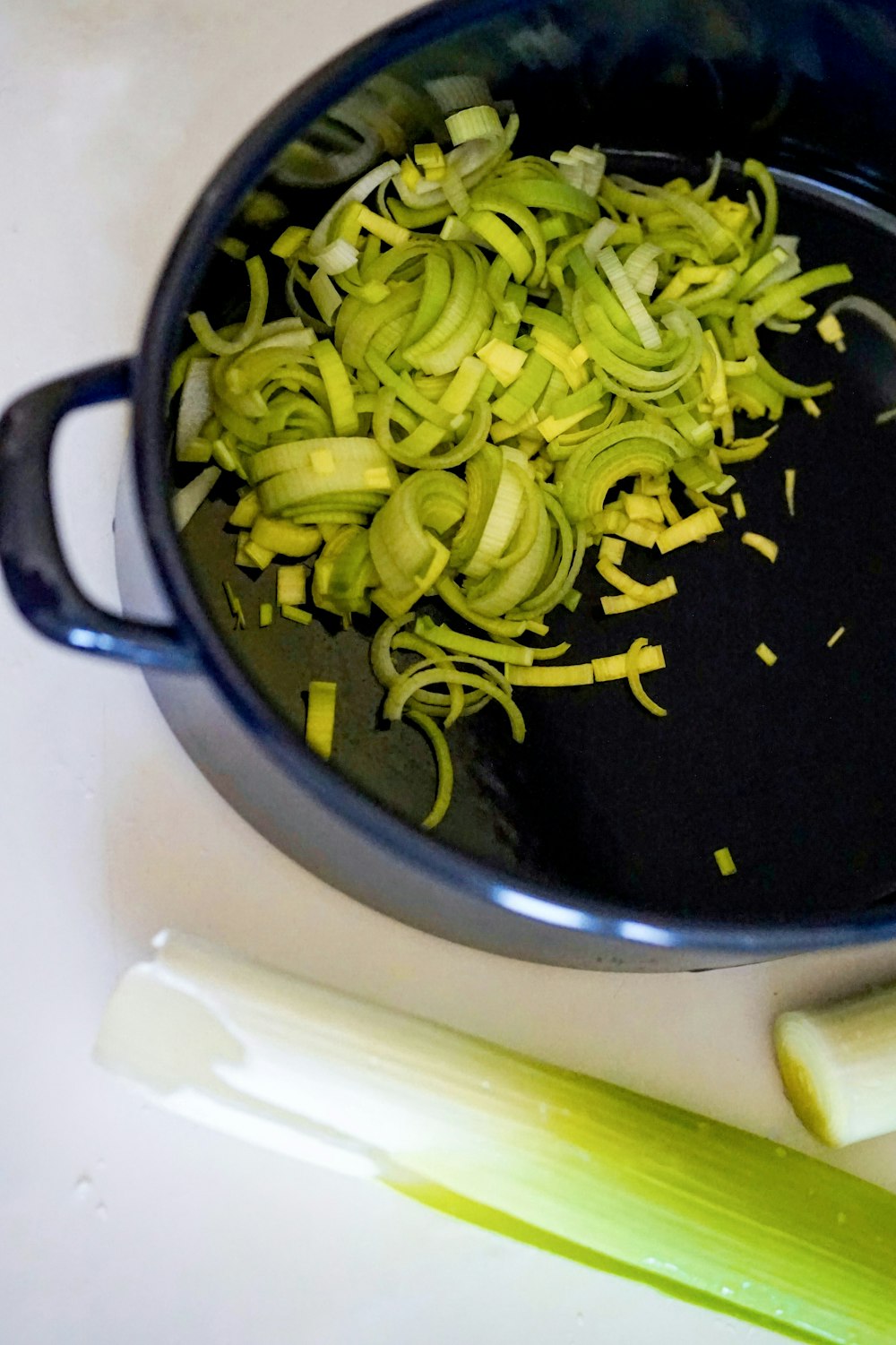 黒い調理鍋に緑の野菜