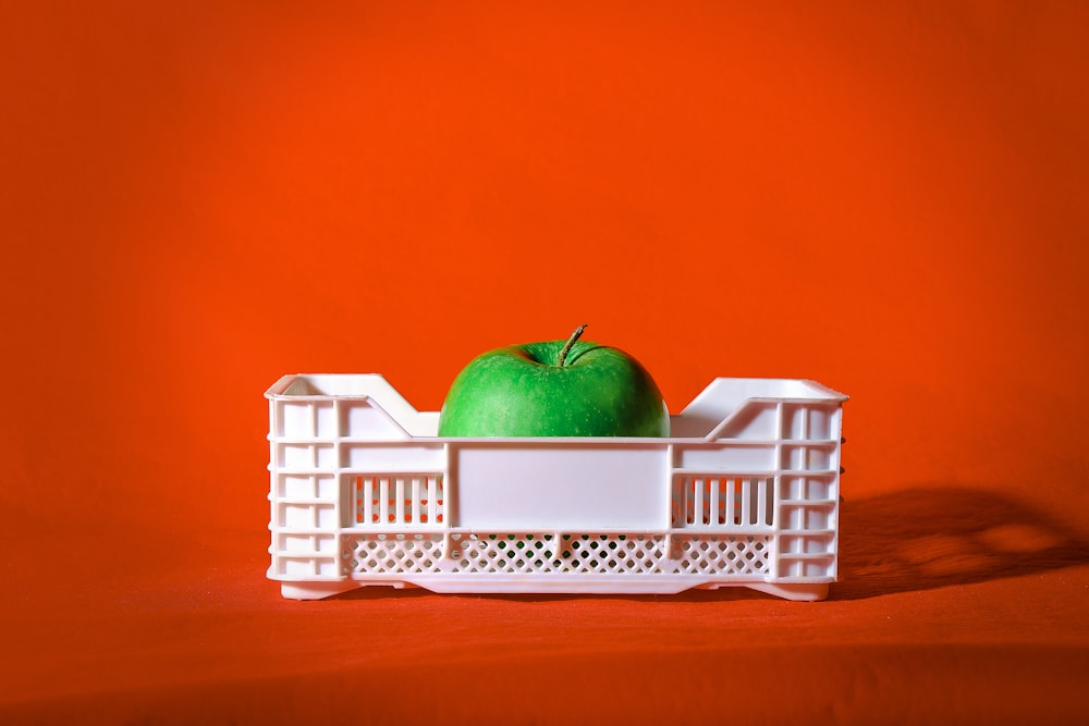 red apple on white plastic crate