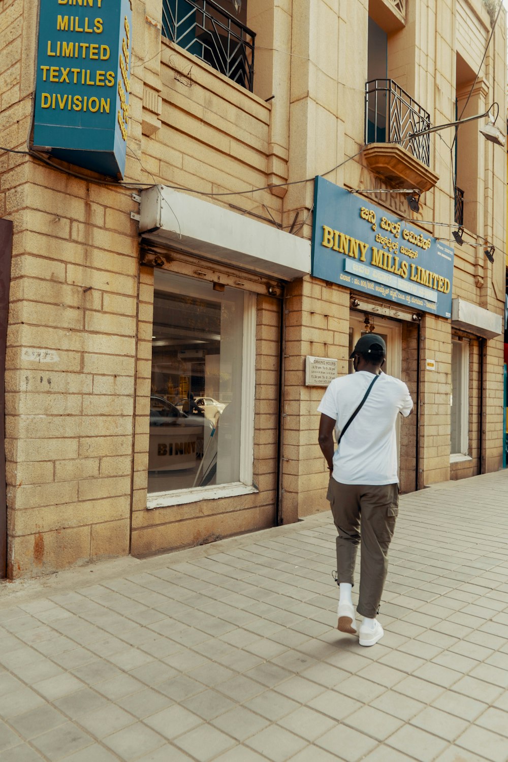 man in white shirt and gray pants standing in front of UNKs store