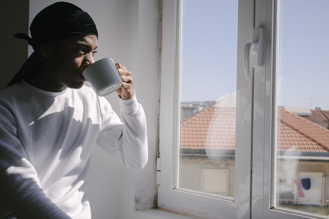 man in white dress shirt drinking from white ceramic mug,