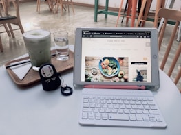 A smiling person reviewing a blog post draft on a tablet in a cozy coffee shop.