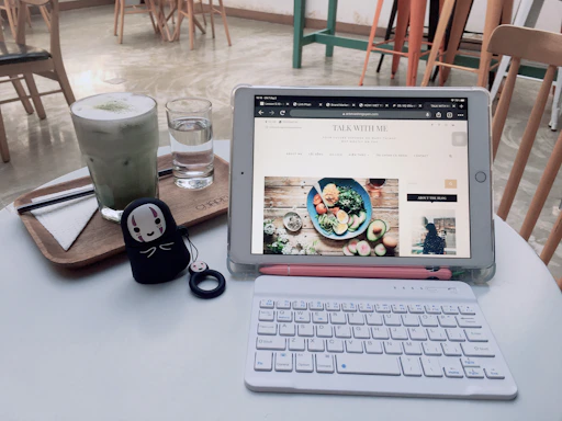 A cozy restaurant table with a digital menu displayed on a tablet next to a fresh salad and a cup of coffee.