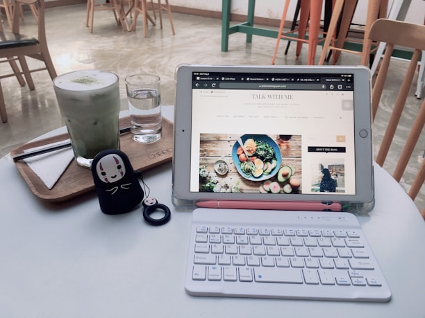 A friendly local café owner showing their new website on a tablet to a customer.