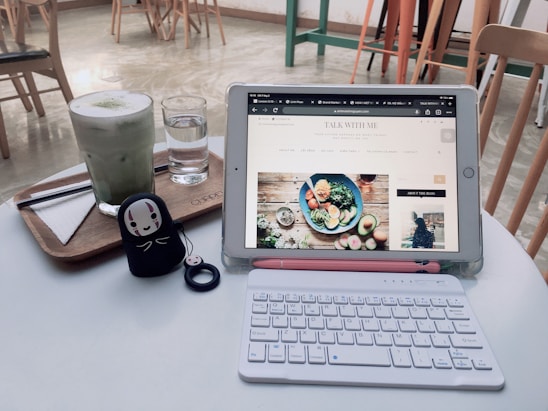 A cozy restaurant owner happily managing online orders on a tablet with golden and white branding accents.