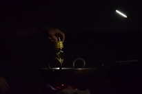 Close-up of golden olive oil being poured into a traditional Indian cooking pan.