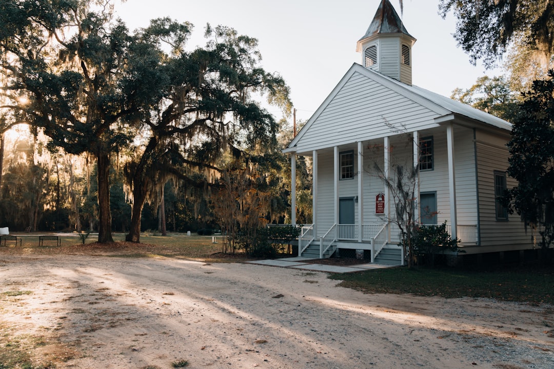 white wooden house near green trees during daytime