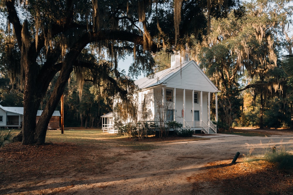 white wooden house near trees during daytime