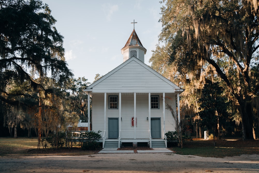 église en bois blanc et brun près des arbres verts pendant la journée