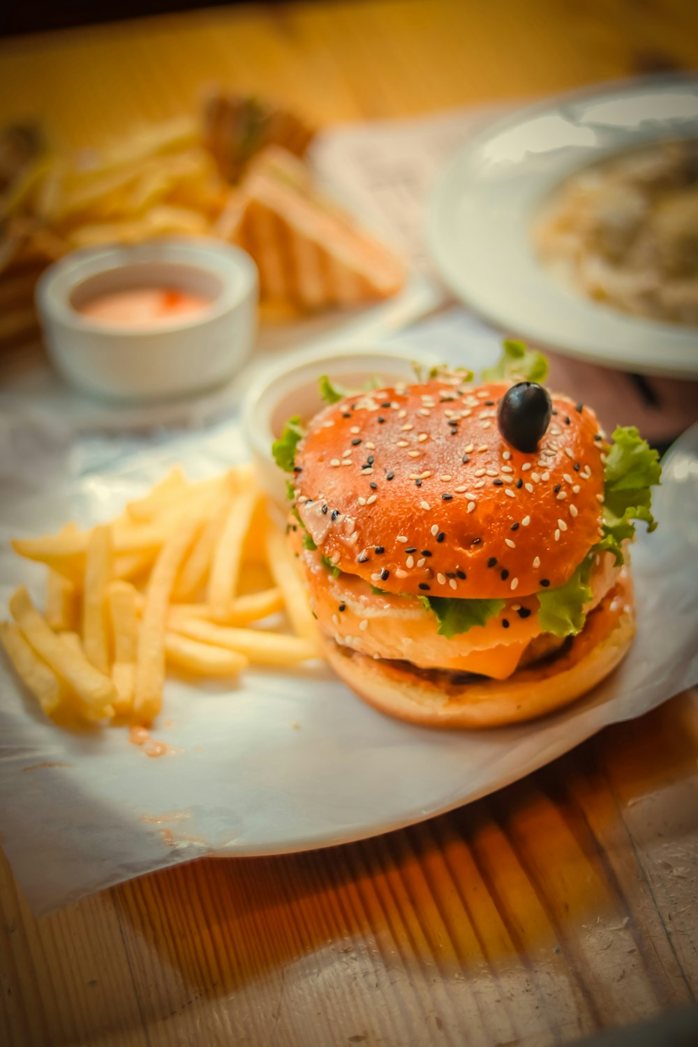 Hamburger con patatine fritte su piatto di ceramica bianca