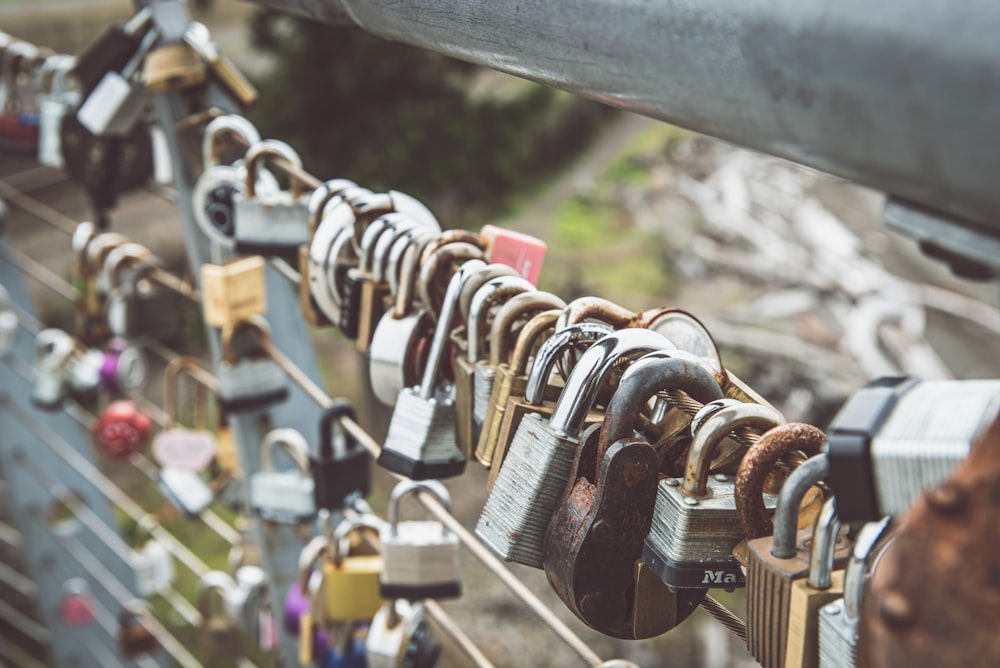 padlocks on brown metal fence during daytime